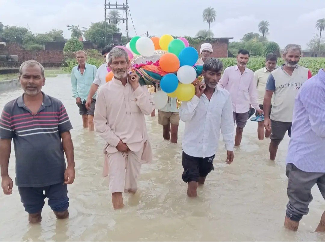 हस्तिनापुर खादर में बाढ़ के पानी से होकर अंतिम संस्कार के लिए जाते ग्रामीण, ऊंची सड़क की मांग